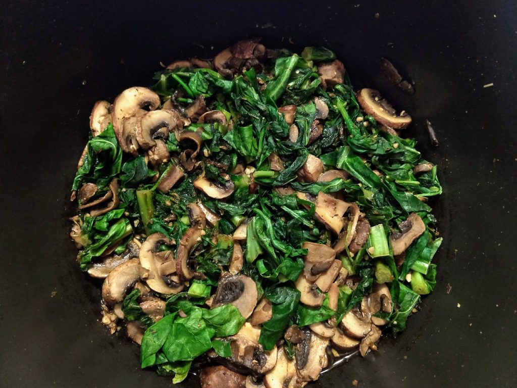 mushrooms and greens, wilted and ready