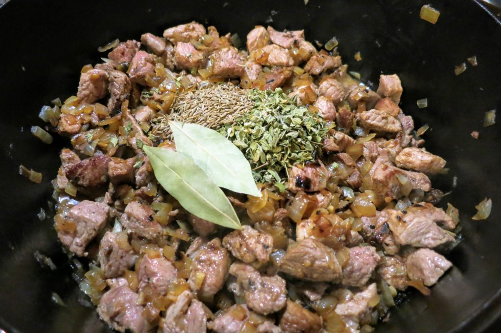 posole onions, pork, and herbs in a pot