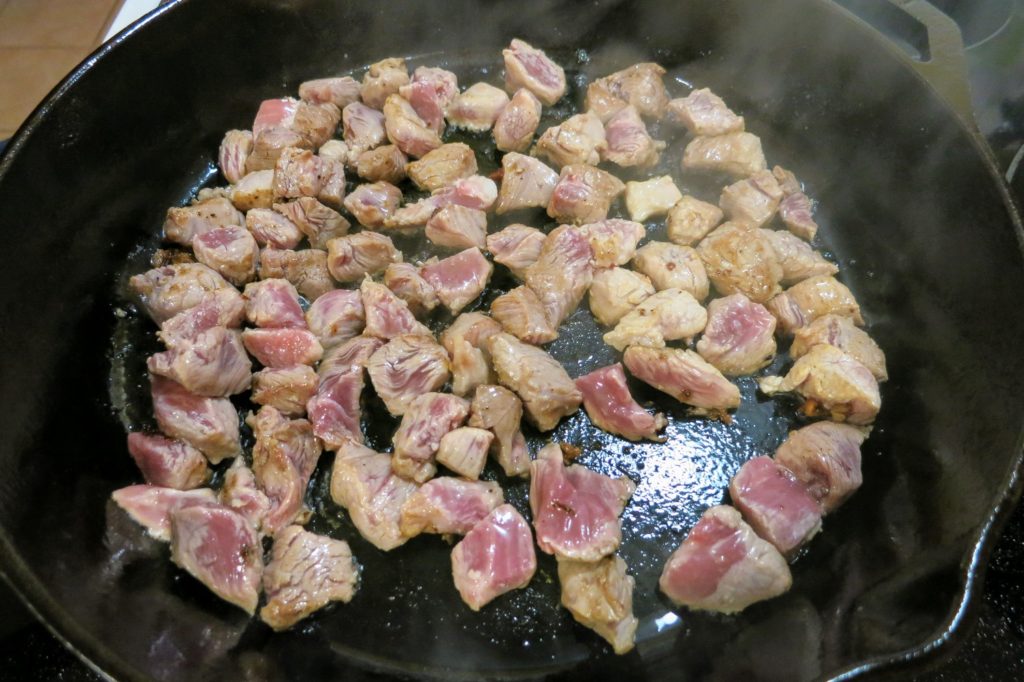 chunks of pork shoulder searing