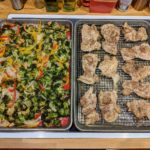 cooked chicken and vegetables on sheet pans