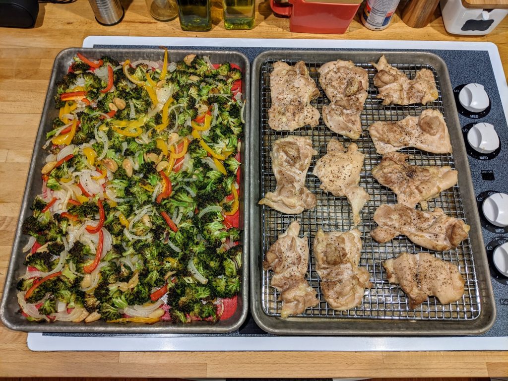 cooked chicken and vegetables on sheet pans